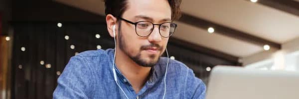Man wearing headphones focused on computer