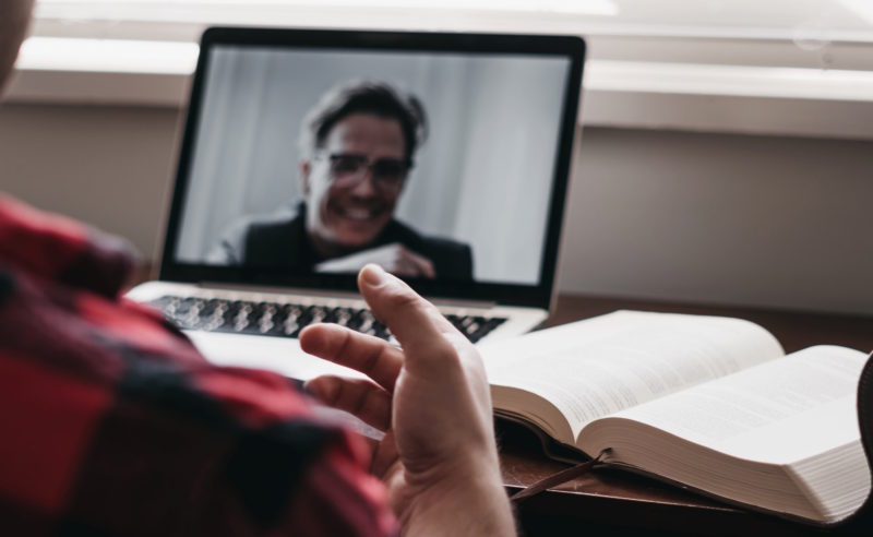 A manager talks to an employee on his distributed team over video chat
